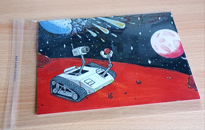 A5 Print of a Mars exploration robot looking intently at a small rock while a planet explodes in the background raining down a shower of meteors. The print is packaged in a cellophane bag